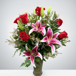 Bouquet of red roses and pink lilies in a glass vase