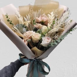Bouquet of blush and cream roses wrapped in beige paper