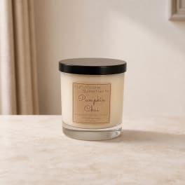 Pumpkin chai candle in a glass jar with a black lid