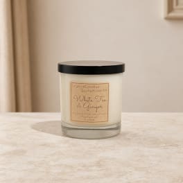 White tea and ginger candle in a glass jar with a black lid