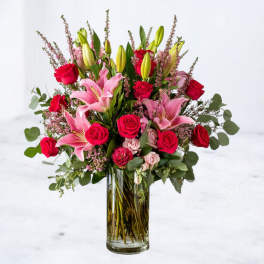 Pink lilies and red roses in a clear glass vase