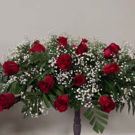 Large red rose arrangement with white baby's breath on a stand