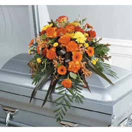Orange and yellow floral spray on a silver casket