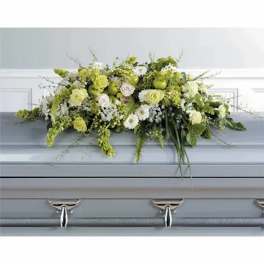 Green and white floral casket spray on a gray casket