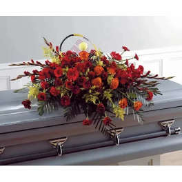 Red and orange floral casket spray on a gray casket