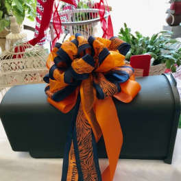 Dark green casket with a large orange and navy ribbon bow