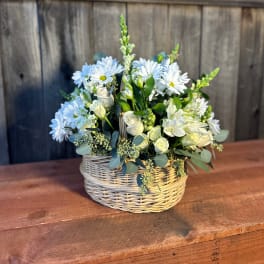White daisies and roses arranged in a wicker basket