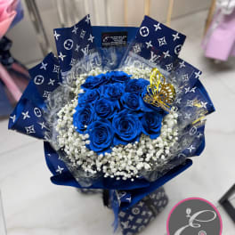Bouquet of vivid blue roses with white baby's breath and a gold butterfly accent