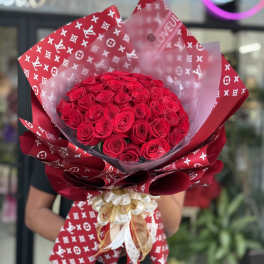 Large bouquet of red roses wrapped in patterned red paper