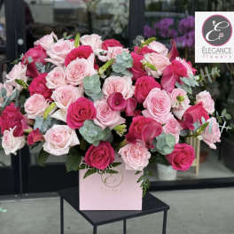 Pink and white rose arrangement in a pink box with eucalyptus