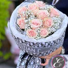 Bouquet of pale pink roses with white baby's breath in decorative wrap