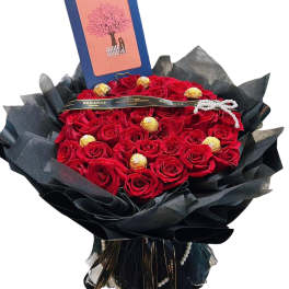 Bouquet of red roses with chocolates and a greeting card