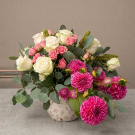 Pink and white roses with magenta dahlias in a patterned vase