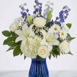 White and blue mixed bouquet in a cobalt glass vase