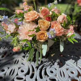 Pastel bouquet of roses and dahlias in a low vase