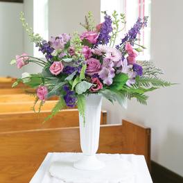 Pink and purple floral arrangement in a white vase