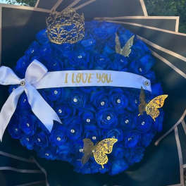 Blue rose bouquet with a white ribbon and decorative crown