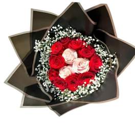 Bouquet of red and pale pink roses wrapped in dark paper