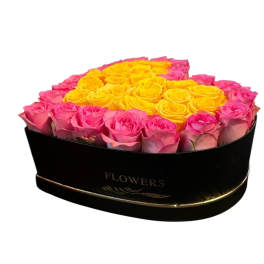 Pink and yellow roses arranged in a black heart-shaped box