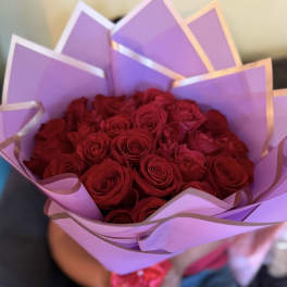 Bouquet of red roses wrapped in lavender paper