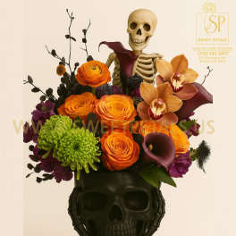 Halloween floral arrangement in a black skull vase with a skeleton topper