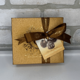 Gold chocolate gift box with brown ribbon and truffle tag