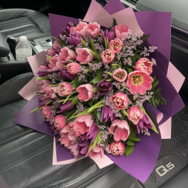 Large bouquet of pink and purple tulips wrapped in pink and purple paper