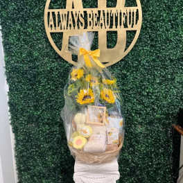 Gift basket with sunflowers and assorted items wrapped in clear cellophane