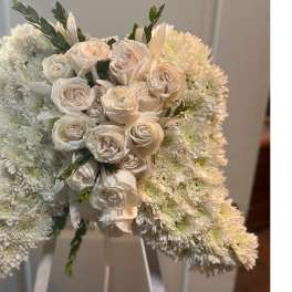 White bell-shaped floral arrangement of chrysanthemums with clustered ivory roses in the center