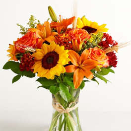 Bouquet of orange and yellow flowers in a clear glass vase