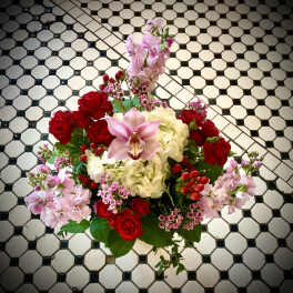 Bouquet of red roses, pink orchids, and white hydrangeas