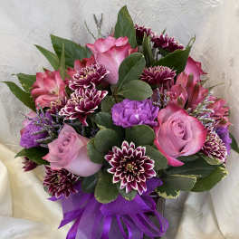 Pink and purple bouquet with roses and chrysanthemums tied with a purple ribbon