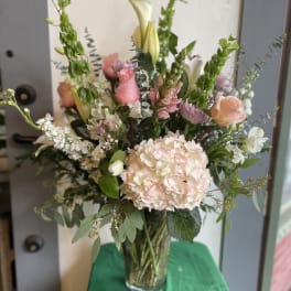 Tall mixed bouquet in a clear glass vase with pink and white flowers
