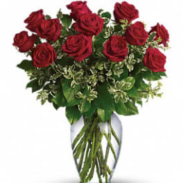 Arrangement of long-stemmed red roses in a clear glass vase