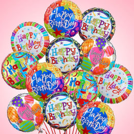 Cluster of colorful Happy Birthday balloons on a pink background