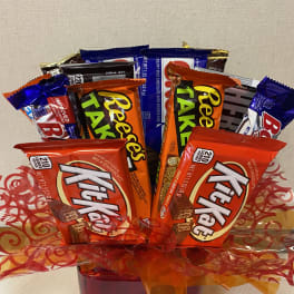 Chocolate candy bouquet in a red container with orange ribbon