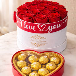 Red roses in a round box with a heart-shaped chocolate box in front