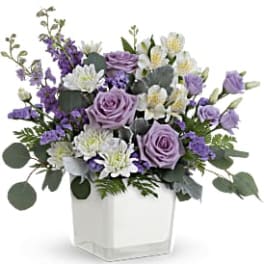 Lavender roses and white flowers in a white square vase
