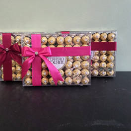 Three boxes of Ferrero Rocher chocolates tied with pink and burgundy ribbons