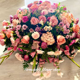 Low dome of pink and peach roses, carnations, and mums in a lush rounded centerpiece