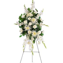 Tall standing spray of white flowers displayed on a metal easel