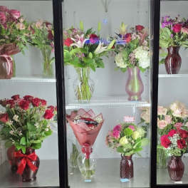 Assorted flower bouquets arranged in vases on display shelves