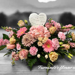 Low pink and peach sympathy arrangement with roses, gerberas, hydrangeas and a heart-shaped angel wings plaque.