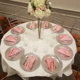 Tall floral centerpiece with white and pink blooms on a banquet table