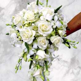 White rose and orchid bridal bouquet with trailing greenery