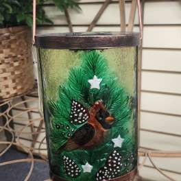 Decorative glass lantern with a painted Christmas tree and bird motif
