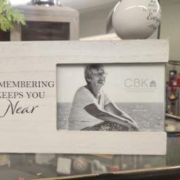 Wooden photo frame with the words "Remembering Keeps You Near"