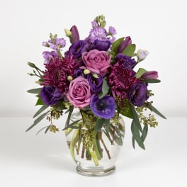 Purple and pink bouquet in a clear glass vase