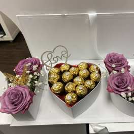 Heart-shaped gift boxes with purple roses and chocolates