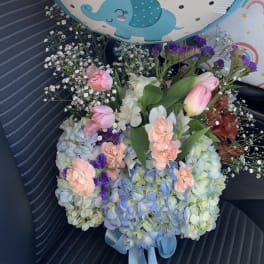 Hydrangeas and roses in a clear vase by lav.ishbouquets